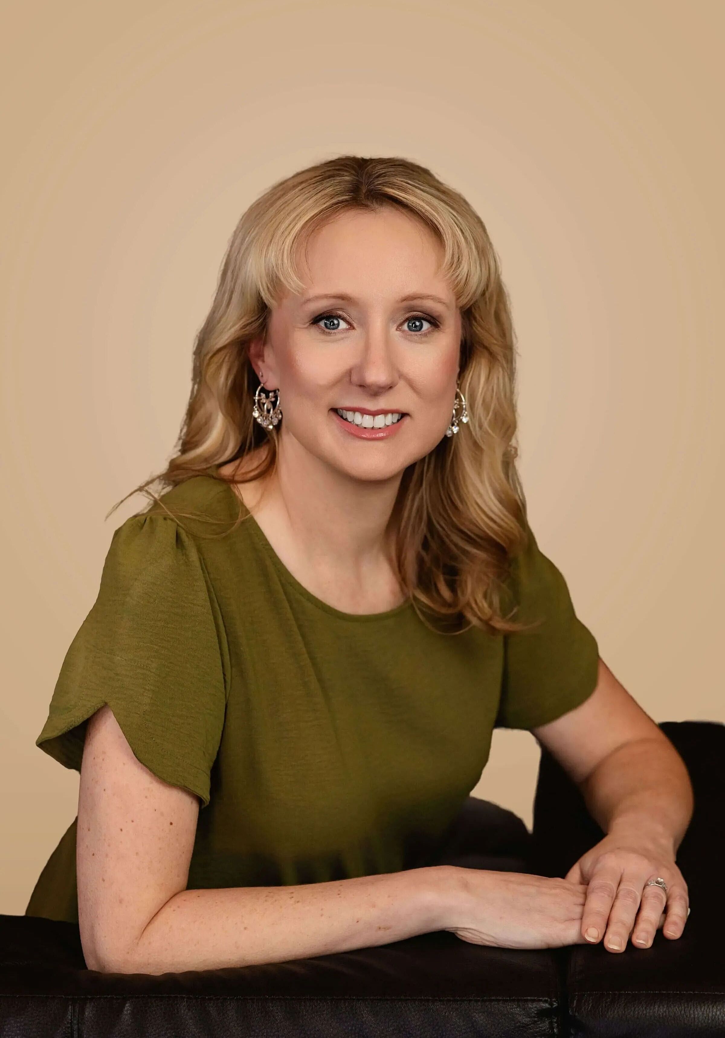 Portrait of a smiling woman seated in a green dress